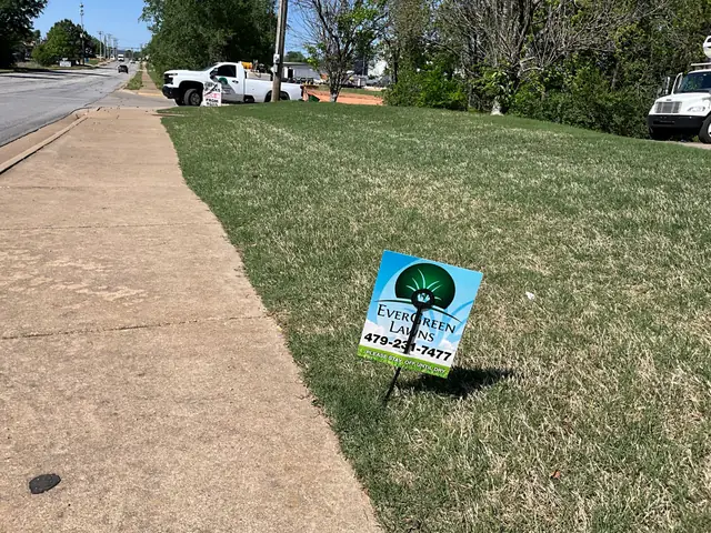 An EverGreen yard flag with the phone number 479-231-7477 planted on a roadside lawn strip